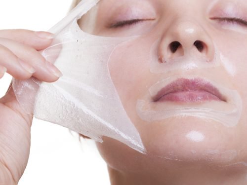 kvinde trækker maske af sit ansigt