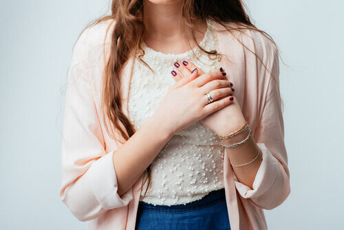 Kvinde holder sig for hjertet