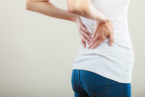 Kvinde med smerter i ryggen