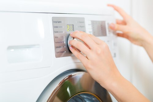 Kvinde der taender vaskemaskinen