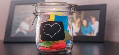 Glaskrukke med lykke har hjerte klistret paa