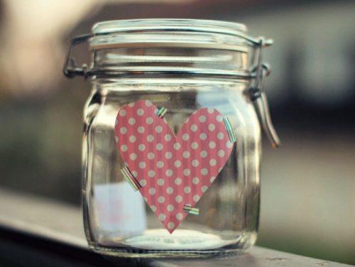 Glaskrukke med lykke har hjerte klistret paa