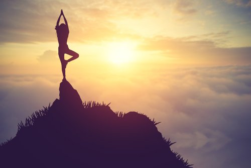 Person der mediterer paa toppen af et bjerg