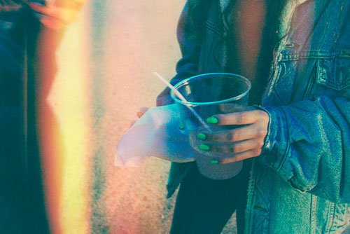Kvinde der holder et plastik krus