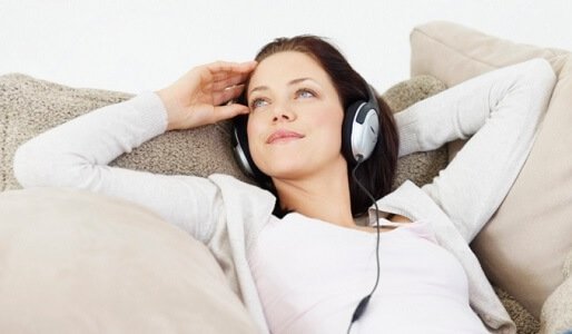 Kvinde der ligger og hoerer musik