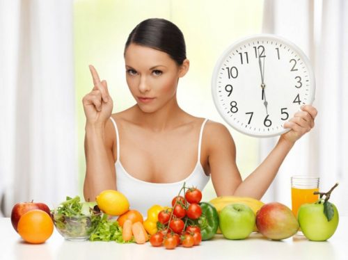 Kvinde med frugt og groent og et ur
