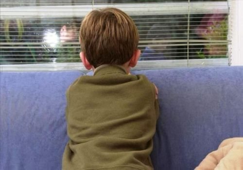 Dreng kigger ud af vindue - identificerer en boernemishandler