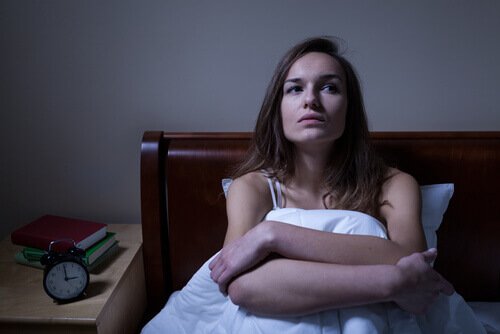 Kvinde der sidder i sengen - natlig panikanfald