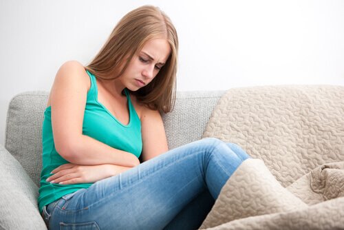 Kvinde med maveproblemer i sofaen