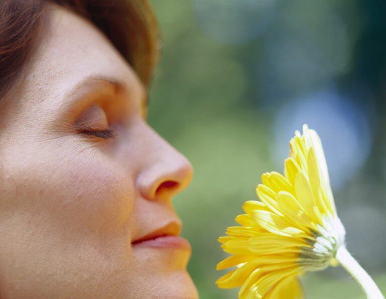 Kvinde der dufter til blomst