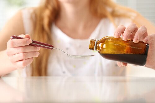 Kvinde haelder hostesirup op