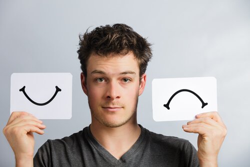 Man der sidder med sur og glad mund - have bipolar lidelse