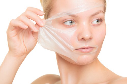 Kvinde der tager en maske af ansigtet