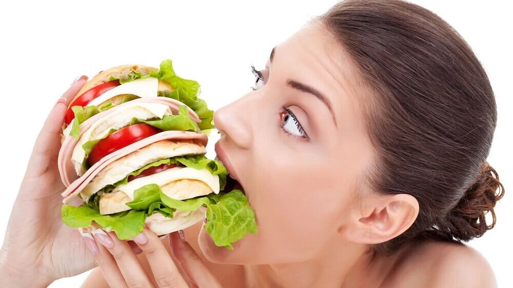 Kvinde spiser kaempe sandwich - konstant sulten