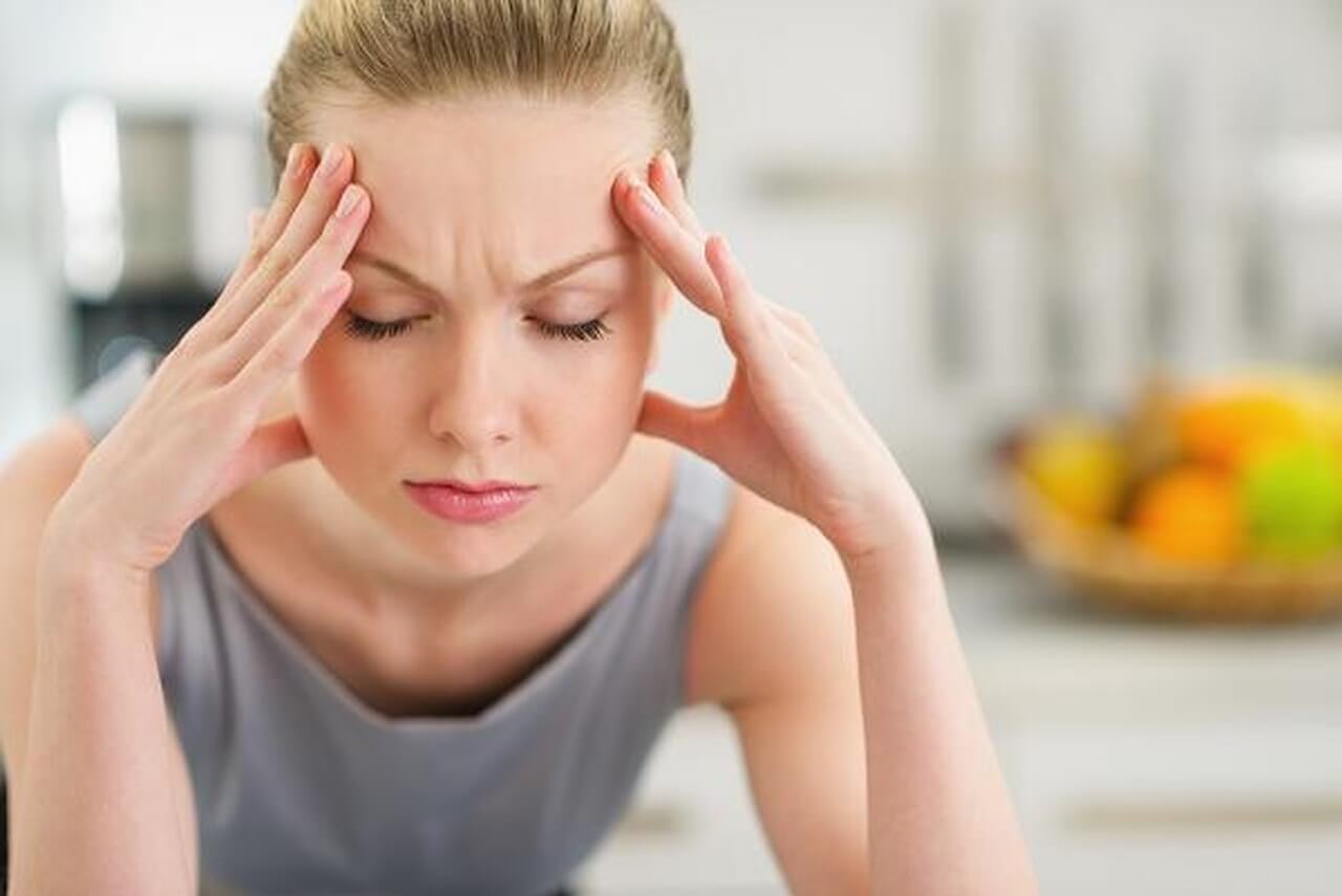 Kvinde med hovedpine - forebygge sure opstoed