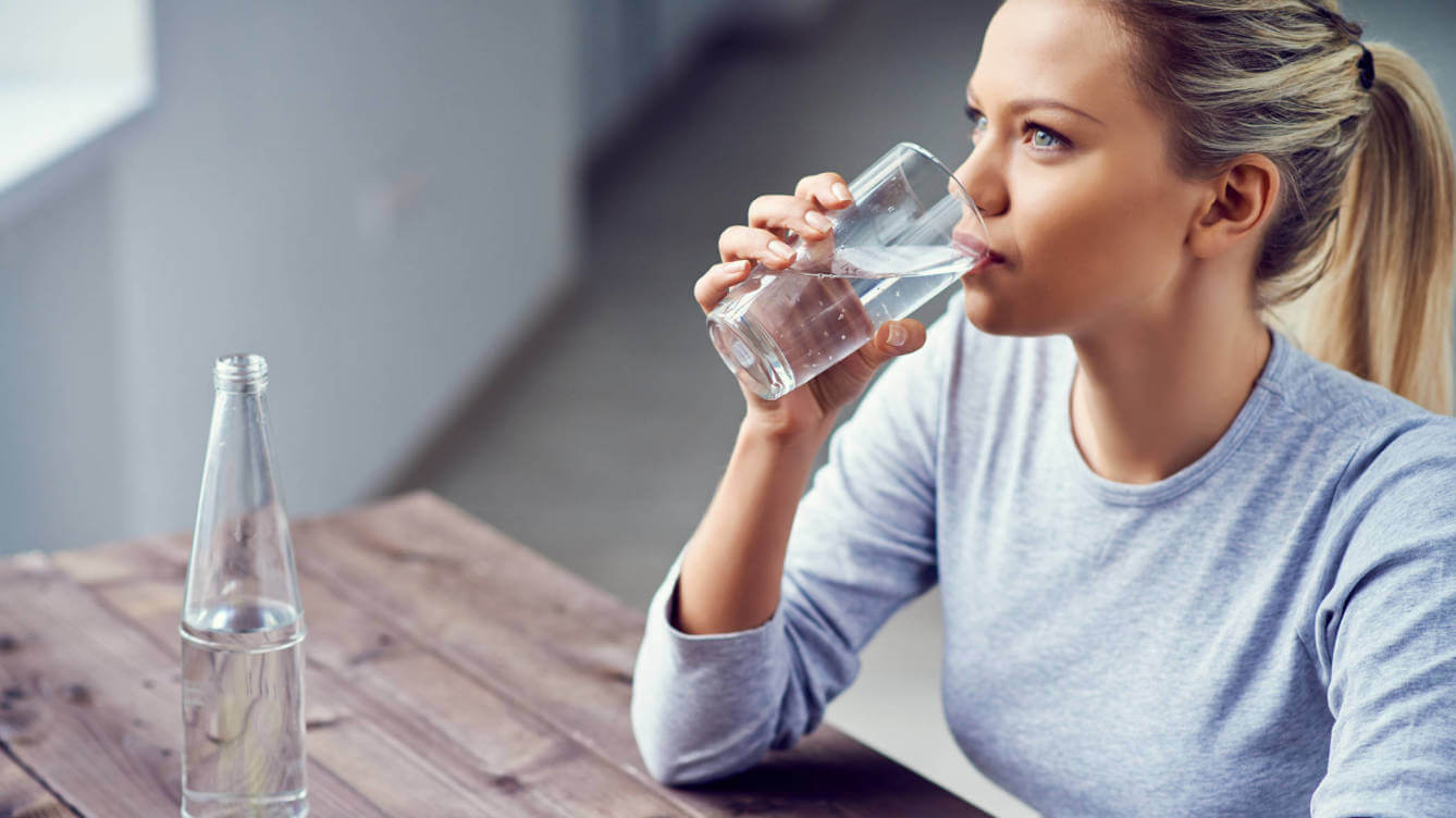 Blond kvinde der drikker vand