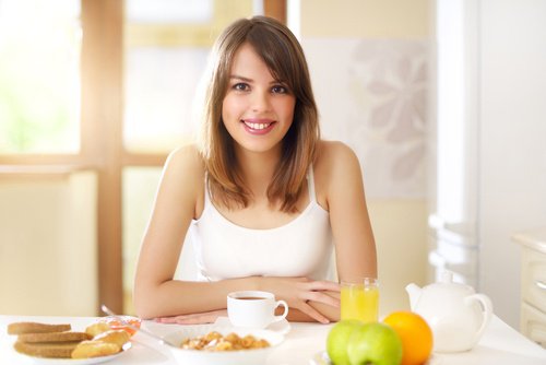 Kvinde der sidder og spiser morgenmad