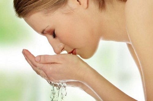 Kvinde vasker ansigtet