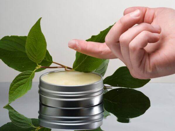 En person dypper sin finger i en boette creme