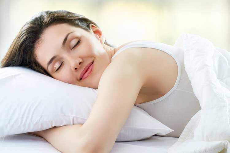 Kvinde sover paa hovedpude - nakkespasmer