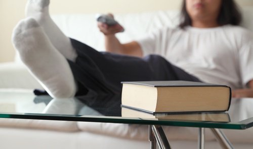 Stor bog paa et bord og person der sidder i en sofa - aelder dig hurtigere