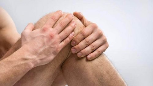 Person der tager sig til knaeet