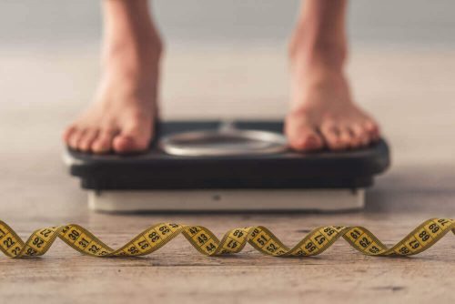 Person står på en badevægt. Vil du tabe 4 kg på 10 dage?