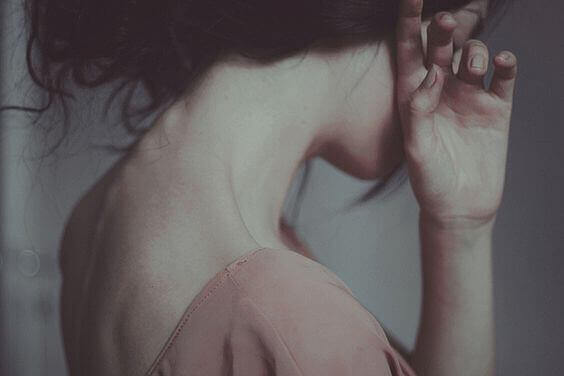 Kvinder der holder haanden for ansigtet