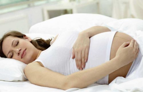 Gravid der sover paa ryggen