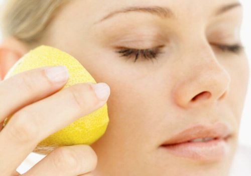 Kvinde der smoerer citron paa kinden - citron som naturlig kosmetik