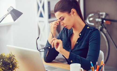 Kvinde der er udmattet paa arbejdet
