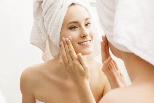 Kvinde der plejer sin hud efter et bad