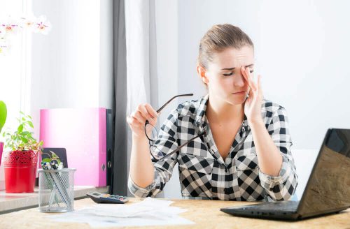 Kvinde der sidder ved computeren med stress