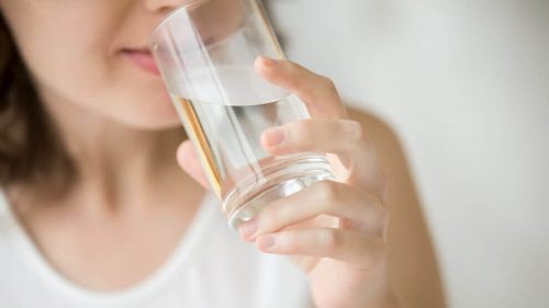 En kvinde der drikker vand - tabe sig under overgangsalderen