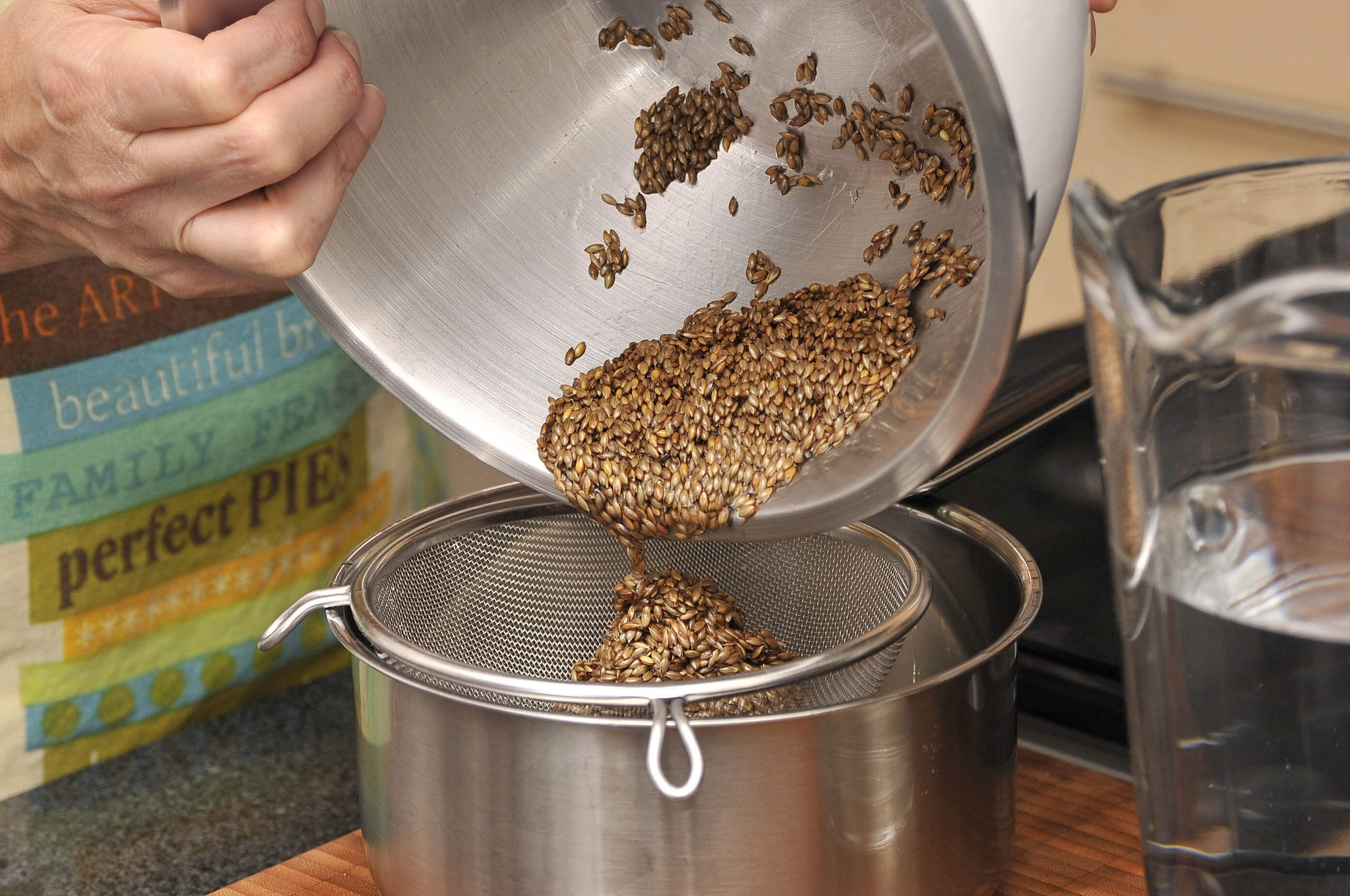 Frø hældes ud i si.