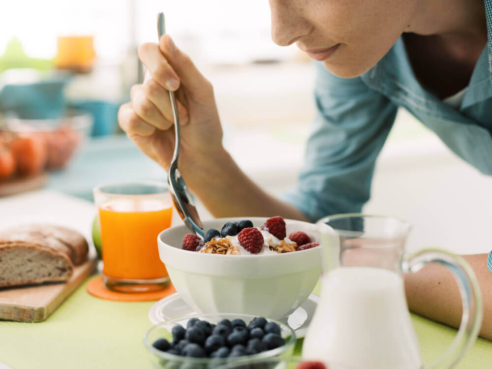 Kvinde spiser en sund morgenmad