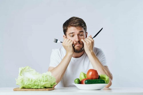 Mand der sidder trist med en salat