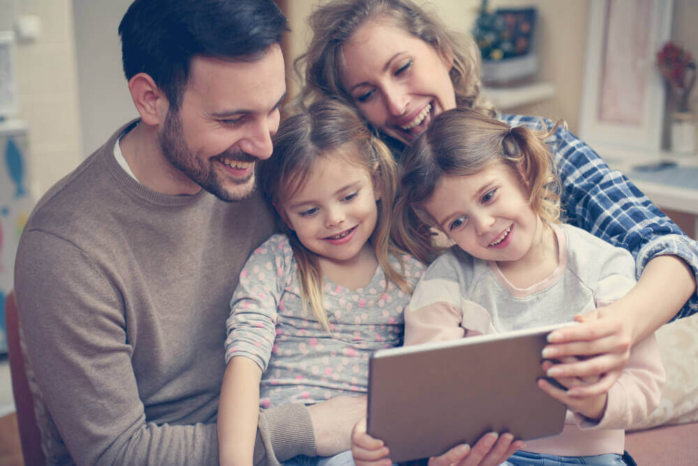 Lykkelig familie med tablet