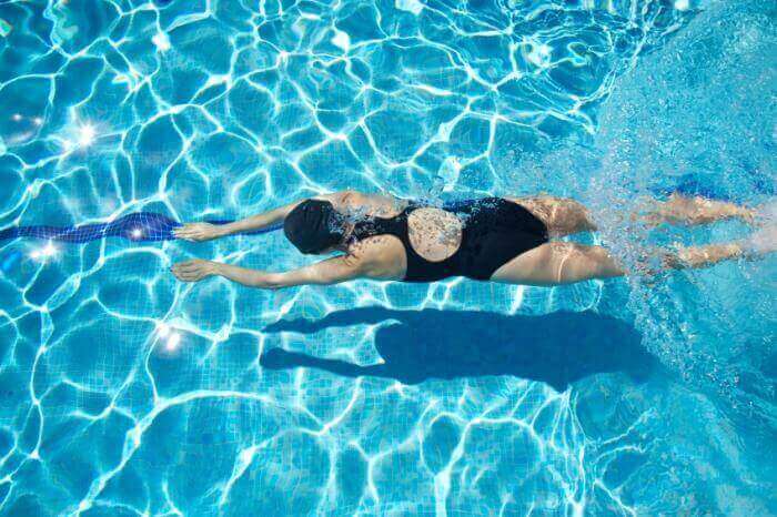 Kvinde svømmer i pool