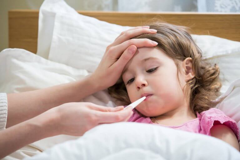 Barn i sengen har temperaturen taget, tør hoste hos børn