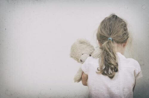 et ensomt barn, der krammer en bamse