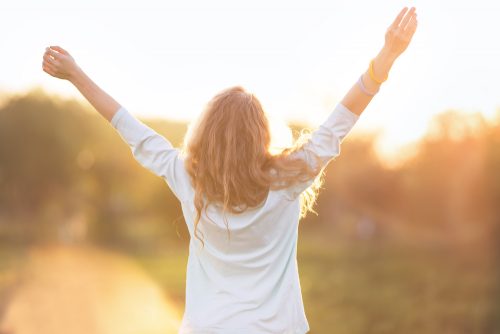 Kvinde som løfter armene i vejret