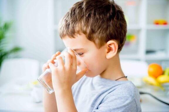 dreng drikker et glas vand for at bekæmpe forstoppelse hos børn