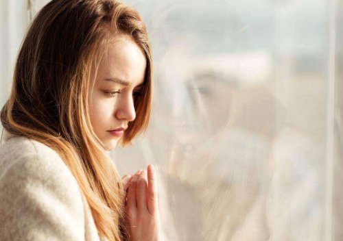 kvinde ved rude i dybe tanker