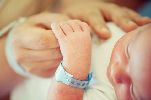 Forælder holder babys hånd som illustration af gulsot hos spædbørn