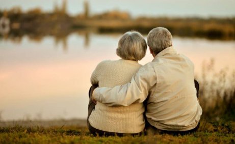 ældre par krammer hinanden og ser ud over sø