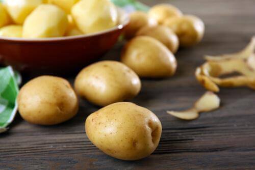 Skrællede og uskrællede kartofler til en opskrift på oksekødsgryde