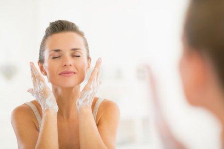 Kvinde foran spejlet vasker ansigt