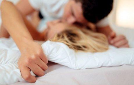 Mand og kvinde kysser og prøver at undgå fejl i sengen