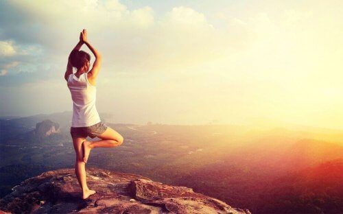 Kvinde på bjergtop dyrker yoga til vægttab